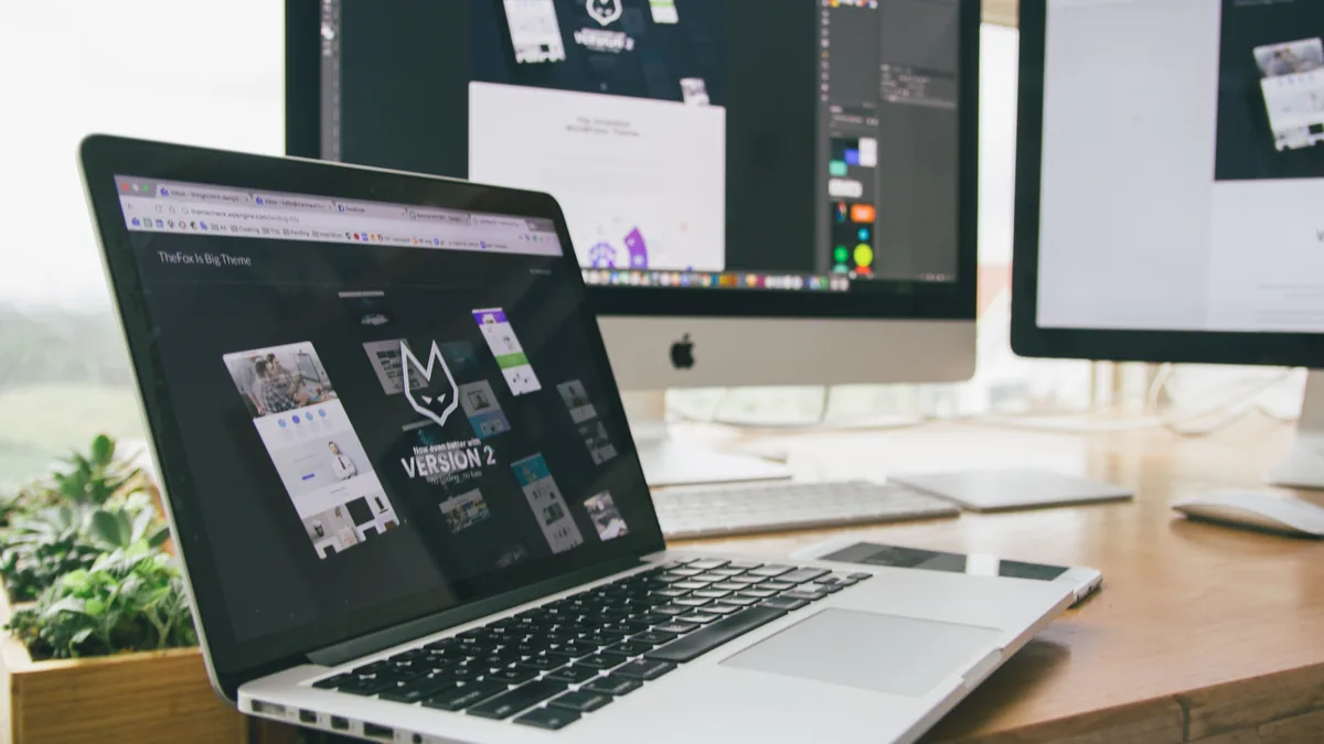 Puesto de trabajo de diseño web con un portátil y una pantalla